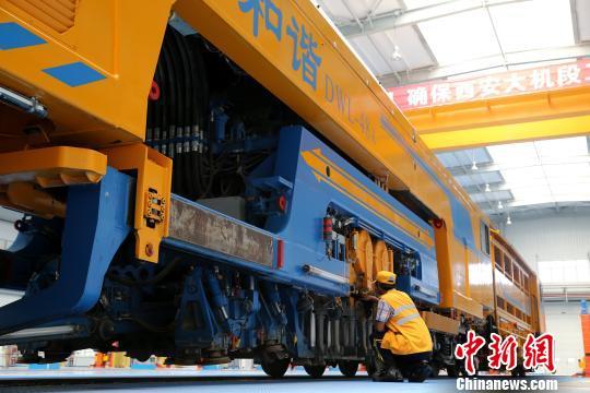 圖為工人正在清理大型養(yǎng)路機(jī)械?！堖h(yuǎn) 攝